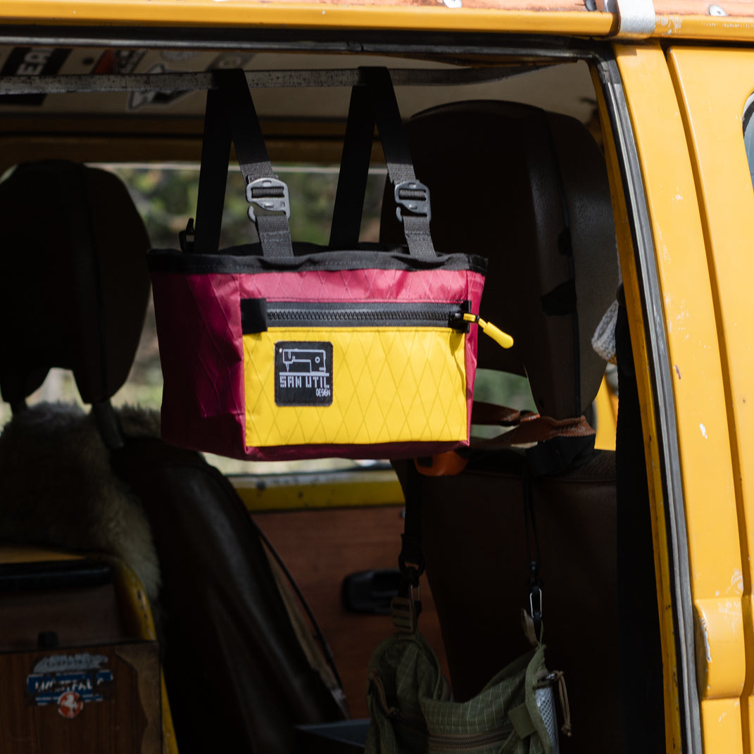 A new product by San Util Design called a 6 Pack Beer Tote hanging from an old VW bus. 