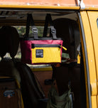 A new product by San Util Design called a 6 Pack Beer Tote hanging from an old VW bus. 